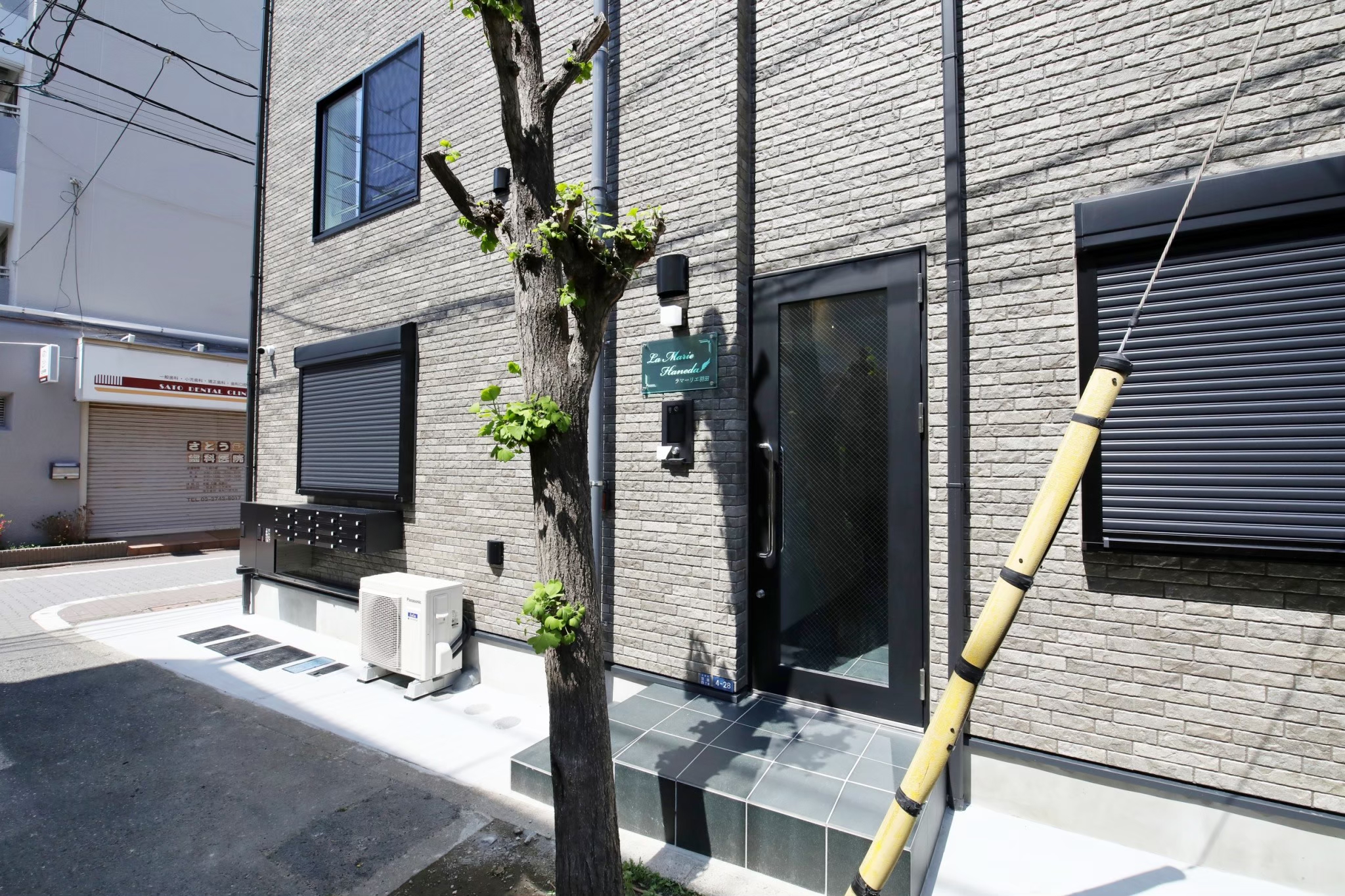 La Marie Haneda building entrance with green sign and grey brick facade